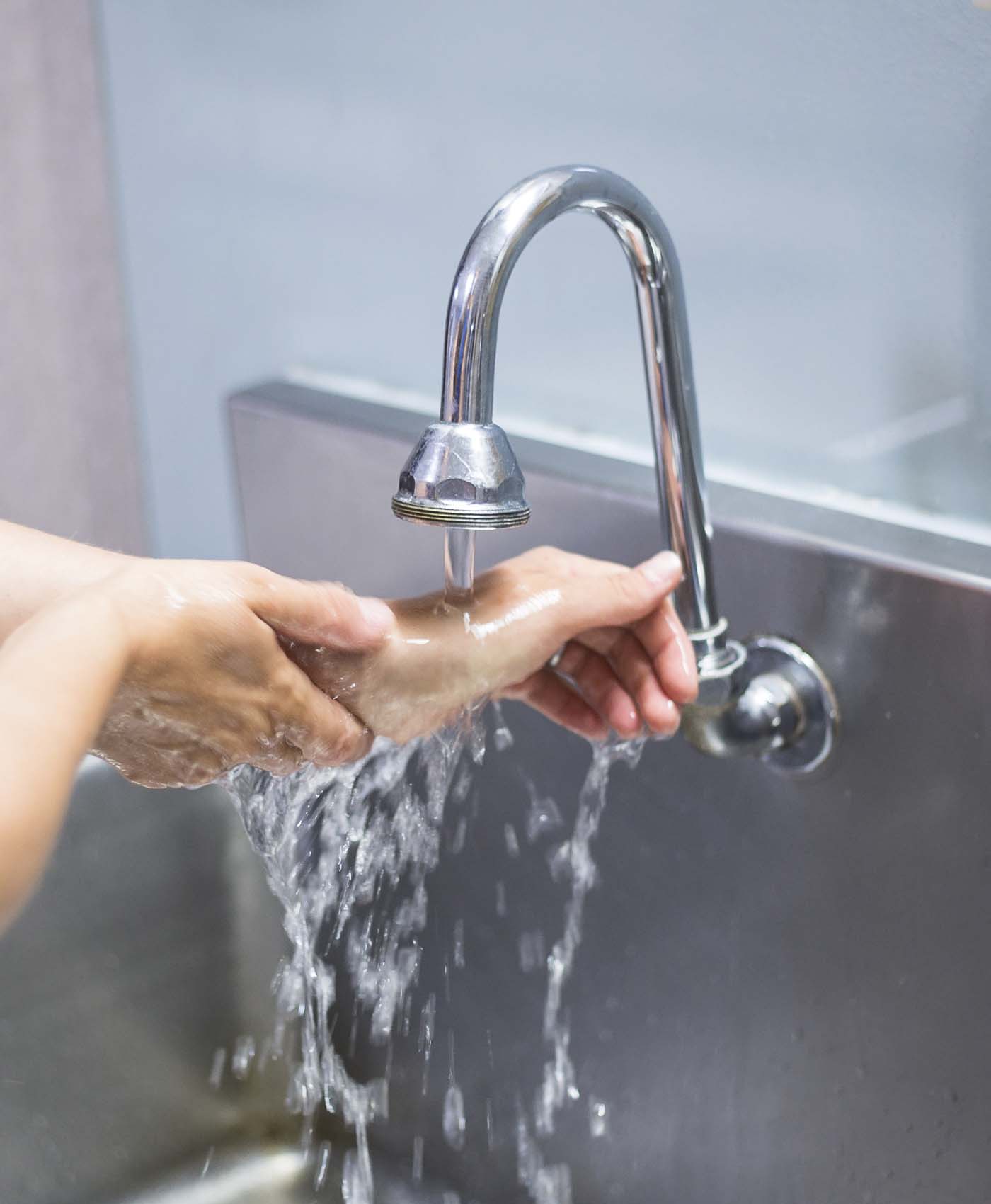 Woman Washing Hands in Medical Setting